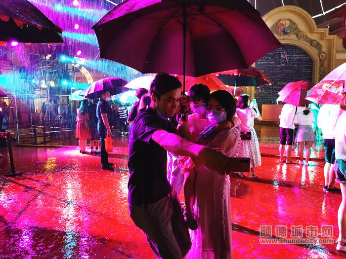 梁先生与妻女站在雨中共撑一把雨伞自拍。.jpg